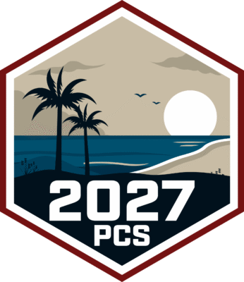 hexagon shape depicting a beach scene with palm trees and a sunset and 2027 PCS on it.